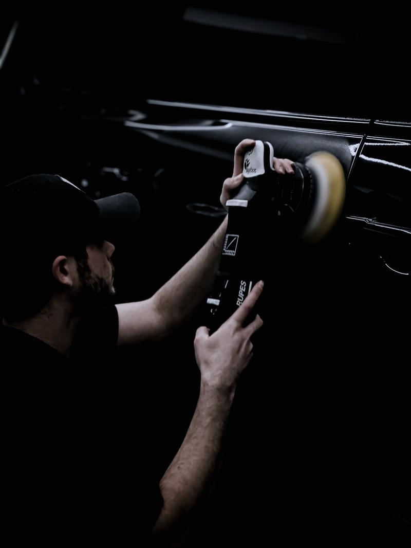 Detailer refining a panel with a machine polisher