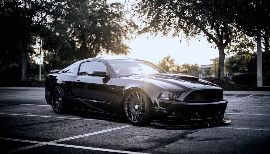 Black muscle car backlit at golden hour