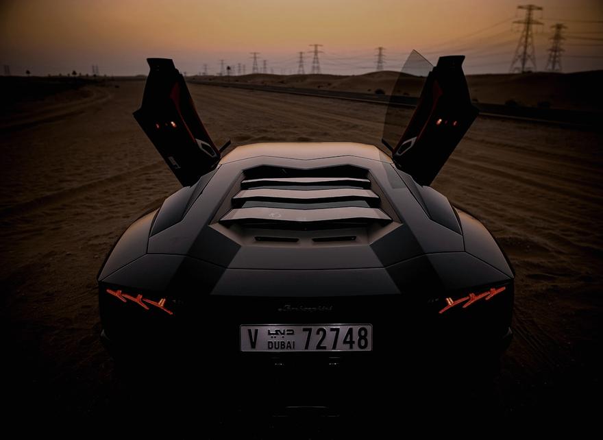 Supercar with doors raised at dusk